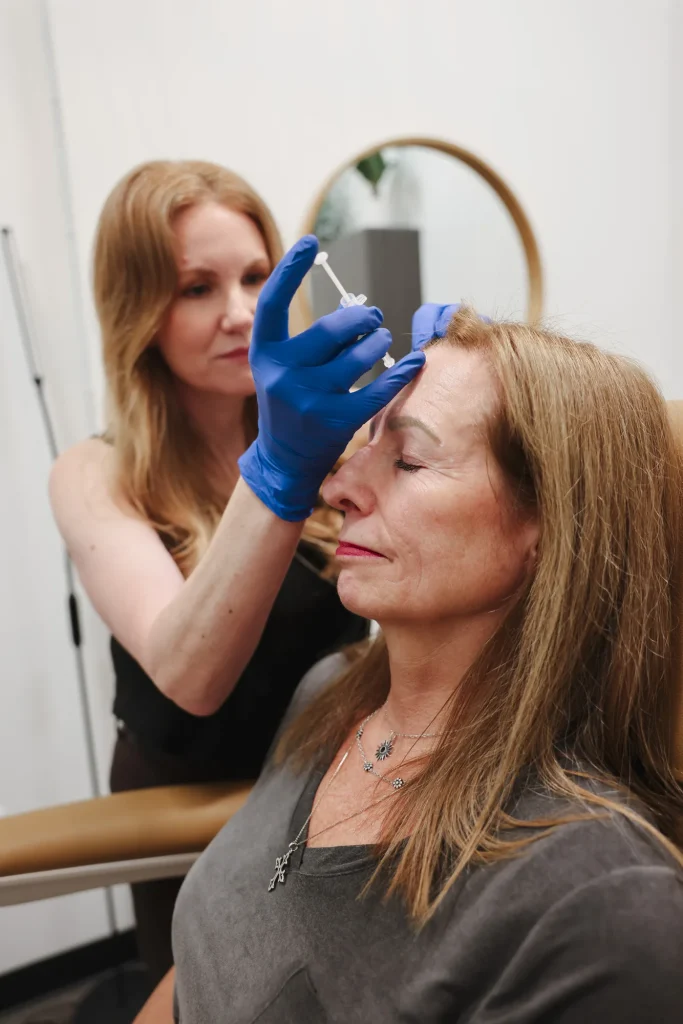 Provider preparing a facial treatment near a patient's brow