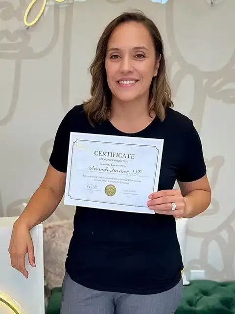 Graduate holding an aesthetic training course completion certificate