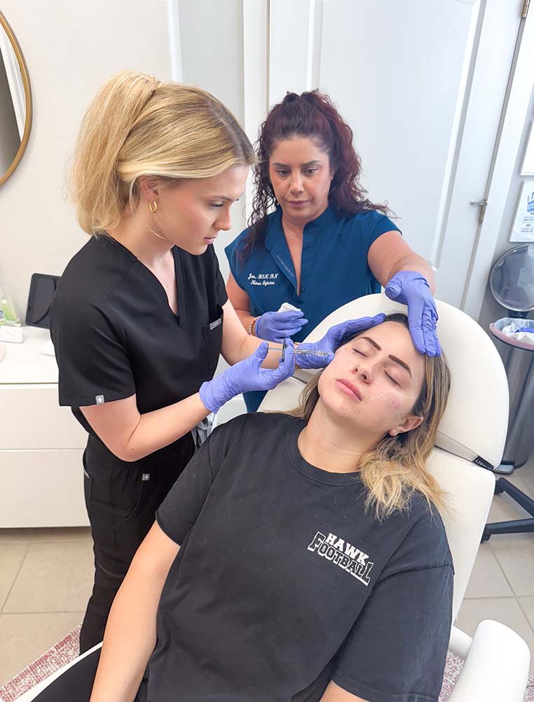 An ITA instructor guiding a student during hands-on training on a live model