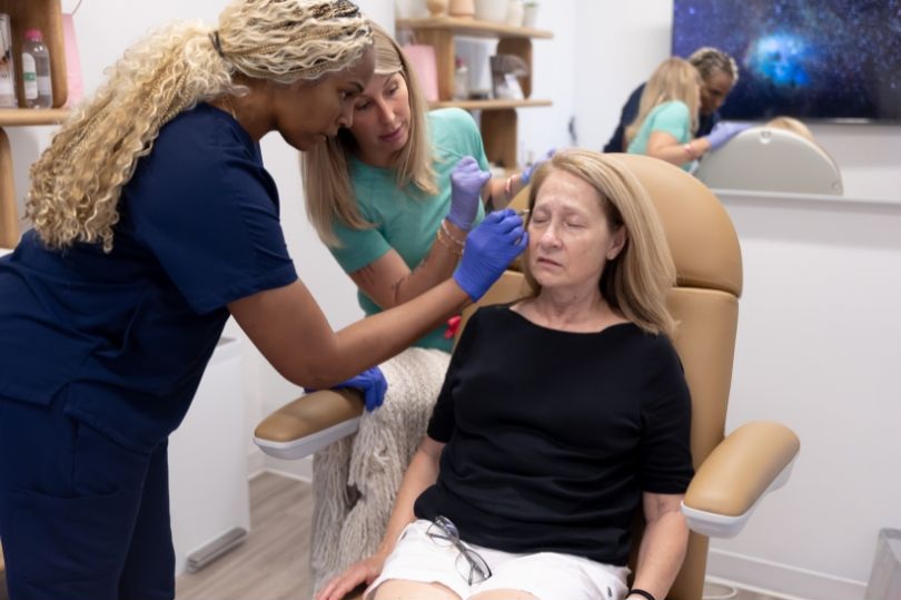 An ITA trainer guiding a student through an injection on a live model