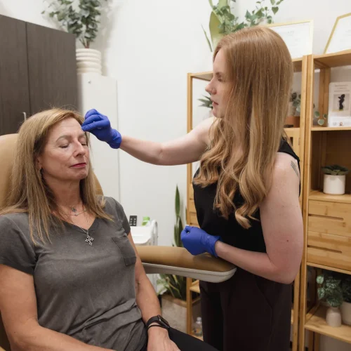 Provider marking a patient's brow before an aesthetic treatment